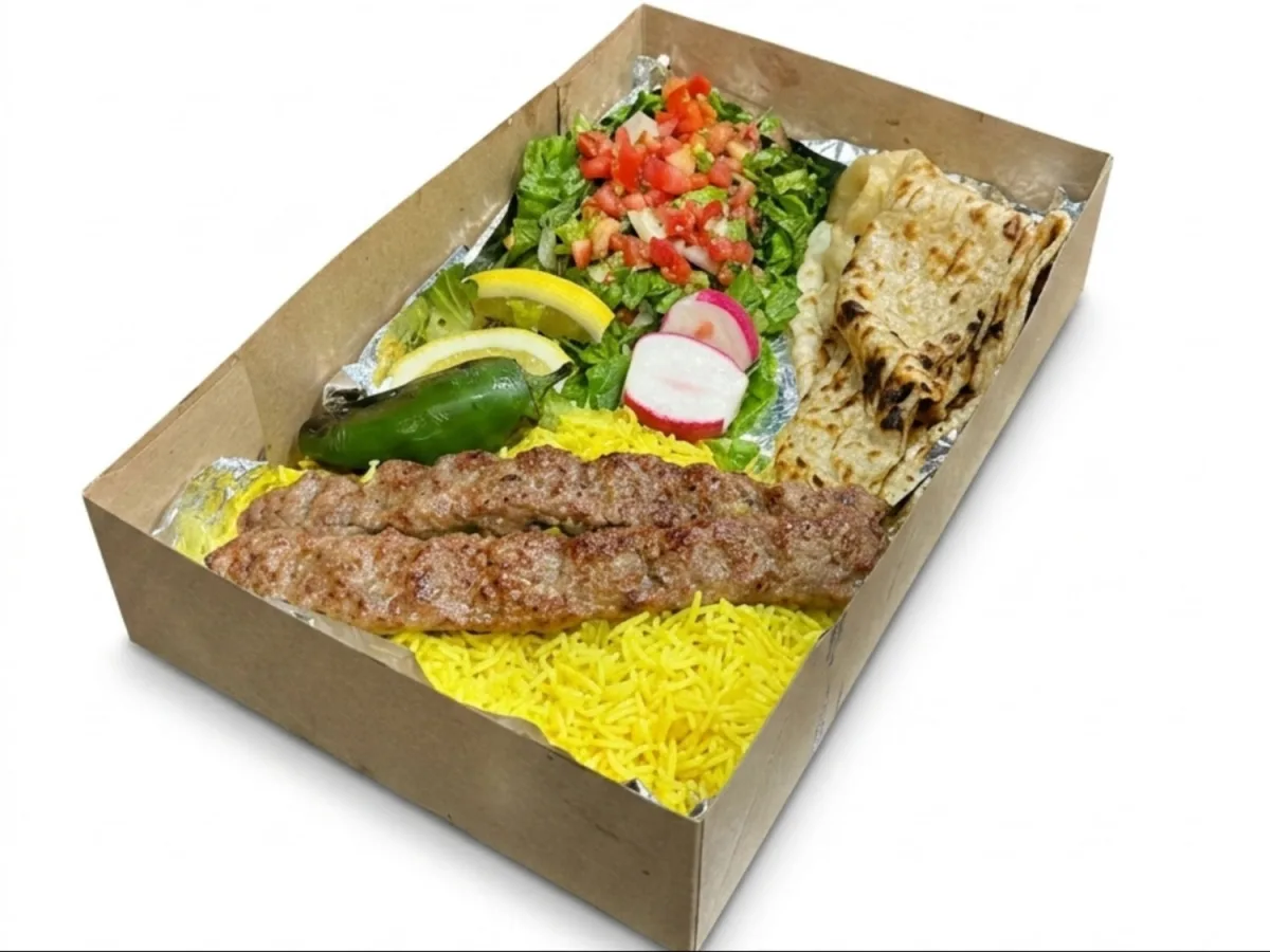 Kubideh plate: two skewers over yellow rice with salad and lavash in a kraft box